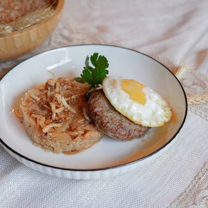 Мясной бифштекс с яйцом и жареной капустой