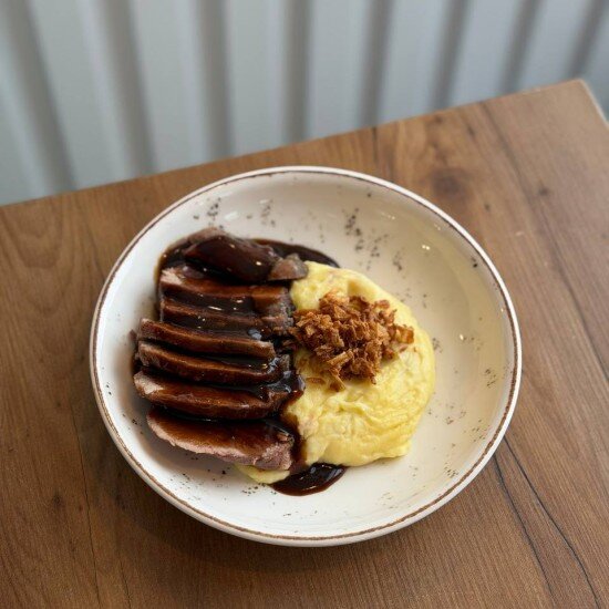 Свинина су-вид с гранатовым соусом на подушке из картофельного пюре с беконом