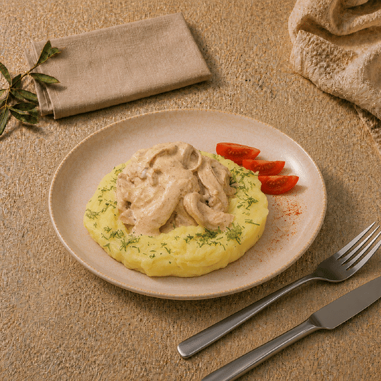 Строганов из курицы с грибами на картофельной подушке